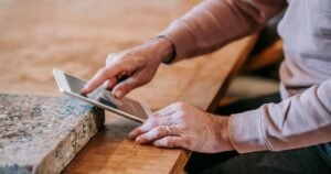 Mãos de profissional usando um tablet sobre a bancada de trabalho
